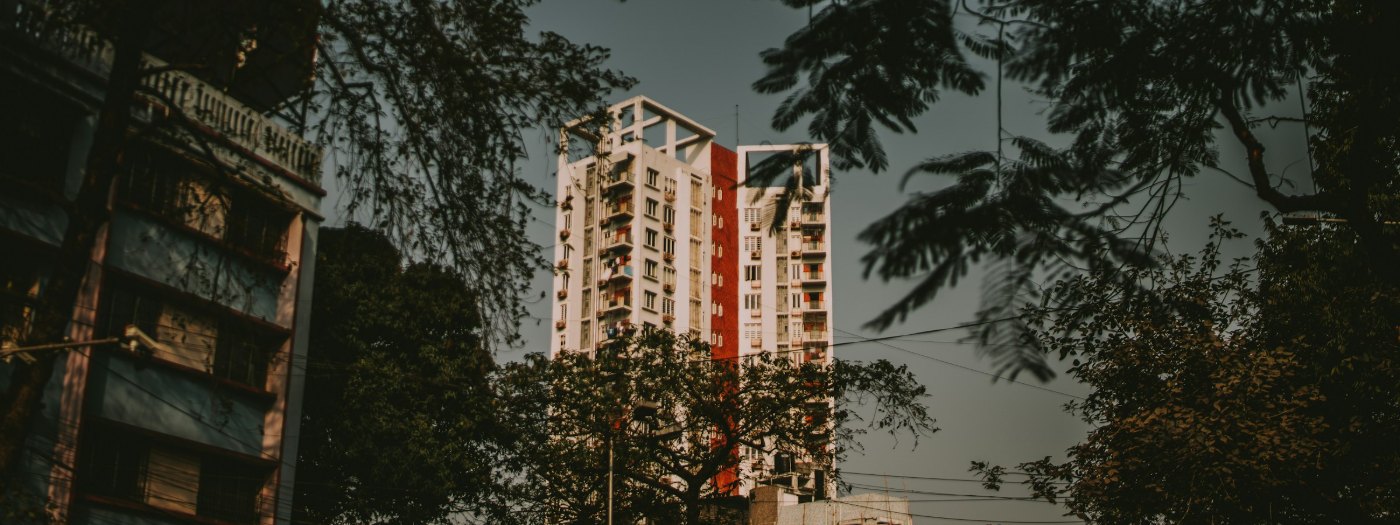 An apartment building seen through trees at dusk