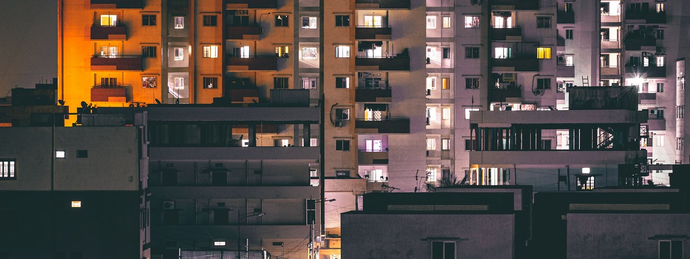Lit apartment windows across a residential block at night