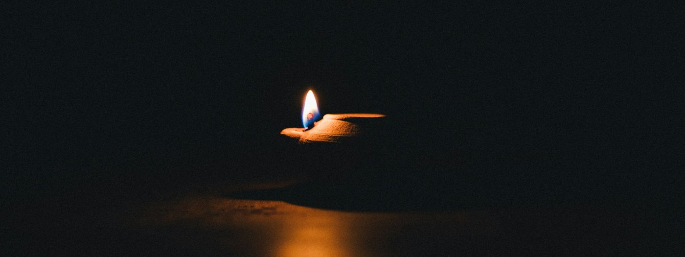A single oil lamp burning in darkness