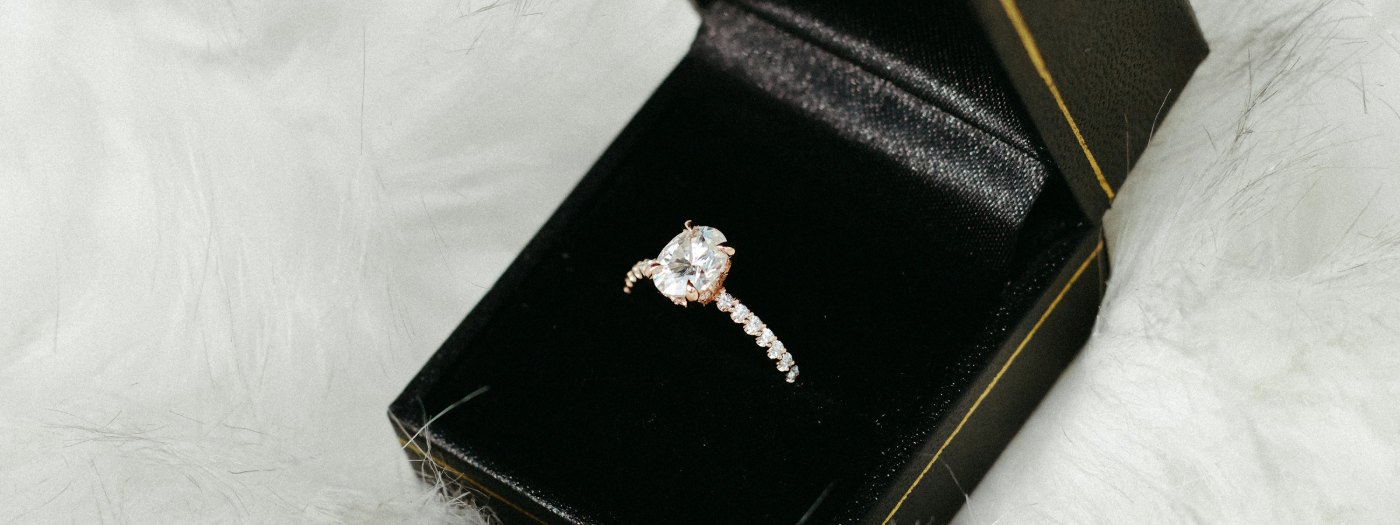 A solitaire diamond ring in a black velvet box