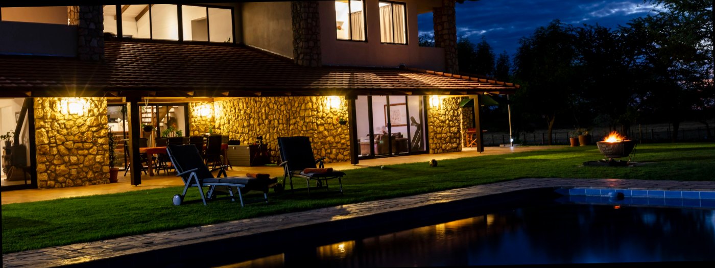 A contemporary villa and pool lit at blue hour