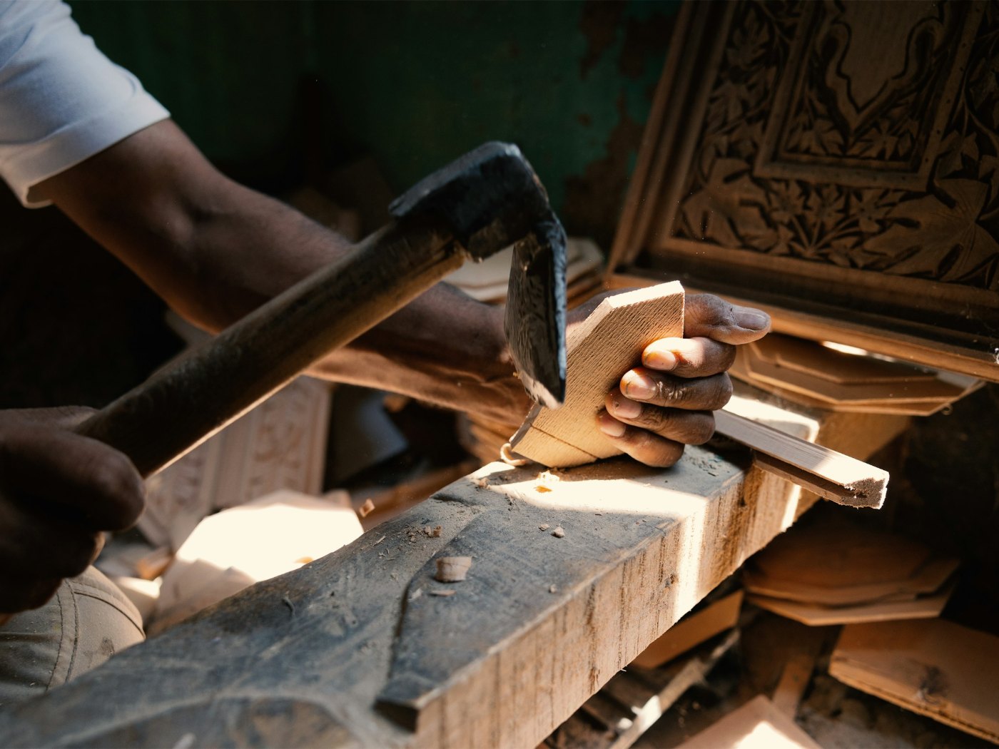 Hands working with a hand tool at a workbench